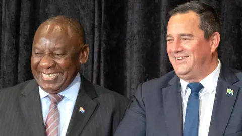 AFP Presiden Afrika Selatan Cyril Ramaphosa (kiri) tersenyum saat Menteri Pertanian Afrika Selatan John Steenhuisen