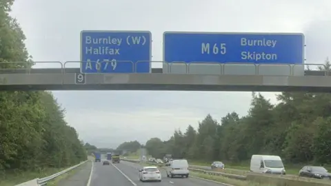 Google Generic image of the M65 motorway at Hapton near Burnley, showing cars driving under a motorway portal