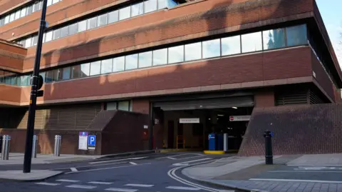 City of Wolverhampton Council The entrance to an indoor car park. The building is red brick and the first, second and third floor have square windows. 