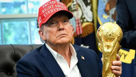 Trump holding the FIFA World Cup trophy in the Oval Office 