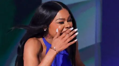 Teyana Taylor with her mouth open and one hand covering it