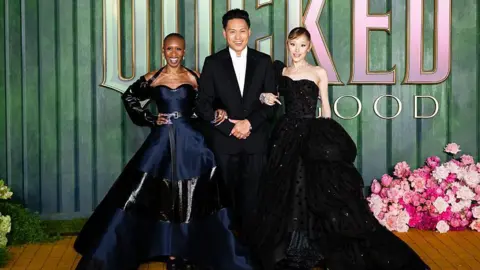 Getty Images (L-R) Cynthia Erivo, Jon M. Chu and Ariana Grande attend the 
