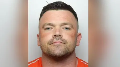 South Yorkshire Police A mugshot of Billy Pemberton who has short brown hair and stubble.