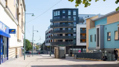 Erith town centre shows Coral betting shop (left) and black-clad flats (centre)