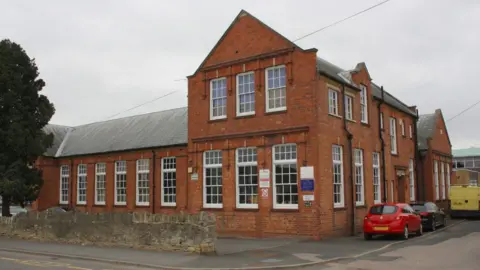 An exterior of a brick-built school building with a slate roof.