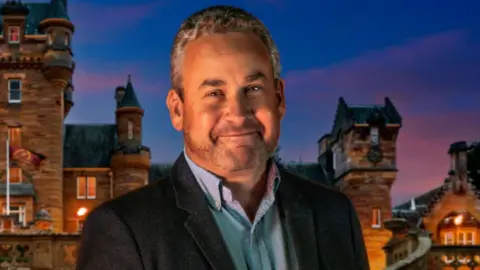 Hugo from The Traitors - guy in a suit