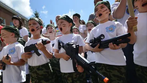 AFP via Getty Images Children scream while holding toy rifles during the military-patriotic game "Zarnitsa" in a kindergarten in Stavropol on June 5, 2015