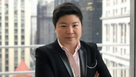 Reddit Jen Wong wearing a black jacket with a light pink shirt