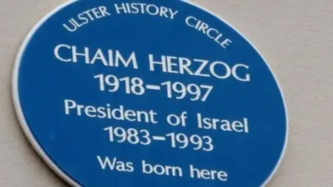 The picture shows a blue plaque saying that Chaim Herozog, the president of Israel from 1983 to 1993, was born here