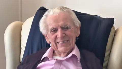 Francis, pictured wearing a pink shirt sitting in his armchair, attended his first Swansea game in 1928.