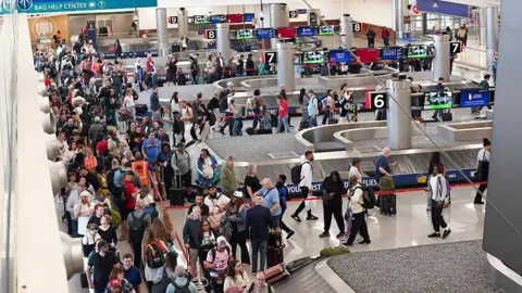 Getty Images Travellers stand in long lines which are snaking around baggage carousels at Atlanta Hartsfield-Jackson International Airport on March 22, 2026 in Atlanta, Georgia. 