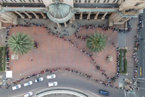 Getty Images Queues of voters outside Johannesburg city hall