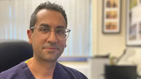 Dr Carter Singh sat in his consultation room at the Willowbrook Medical Practice at Sutton-in-Ashfield, Nottinghamshire