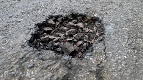 BBC A close-up picture of a filled-in pothole