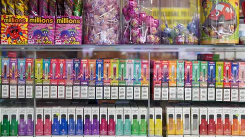 PA Media Generic images of boxes of vapes next to sweets in a store
