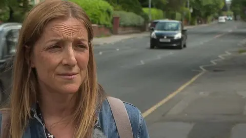 Liz Godfrey of Mums for Lungs standing on pavement of busy road