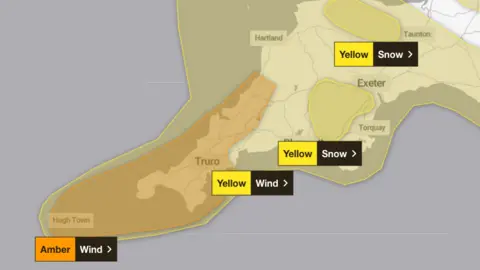 Met Office The image shows a weather warning map for the South West of England, highlighting areas affected by strong winds and snow.
The map uses colour-coded alerts from the Met Office. An amber wind warning covers Cornwall and the Isles of Scilly. This indicates a high risk of severe disruption due to very strong winds. Surrounding this, a yellow wind warning extends across much of Devon and parts of Somerset, signalling less severe but still potentially disruptive conditions.