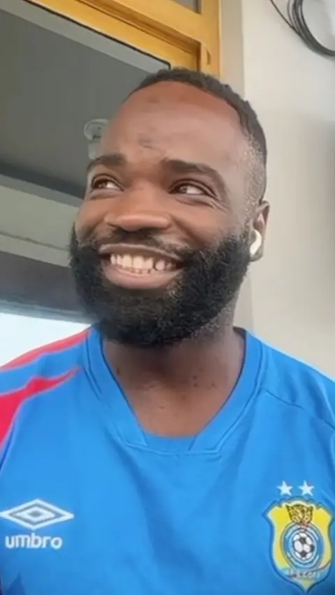 Junior Masandi smiling in a blue DR Congo kit