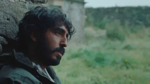 MAD RABBIT LTD 2024 A side image of a man sat against a wall staring ahead