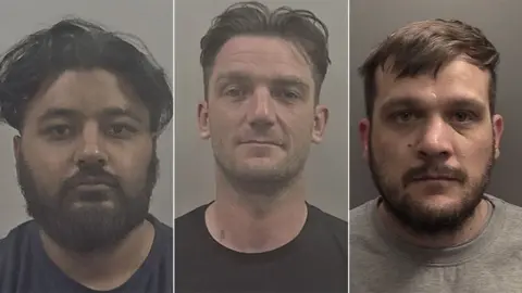 Police custody image of Hazrat Shah, Andrew Fox and Jason Gladding. Shah has black hair and a beard and is wearing a dark-coloured T-shirt. Fox has short dark hair and is wearing a black shirt. Gladding has brown short hair and beard and is wearing a grey shirt.