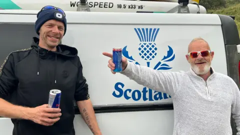 BBC/Inca Martinez Robert Hinchliffe and Richard Steventon stand next to the motorhome they use in Scarborough's North Bay
