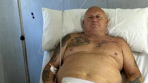 Nigel Hunt in a hospital bed.