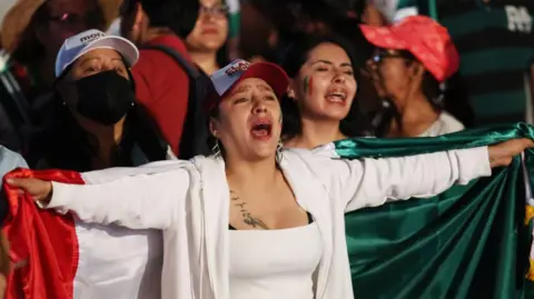 Getty Images Apoiadores da candidata presidencial do partido governista Morena, Claudia Sheinbaum, se reúnem para comemorar os resultados das eleições presidenciais de 2024 no México, na praça Zócalo, na Cidade do México, México, em 3 de junho de 2024.
