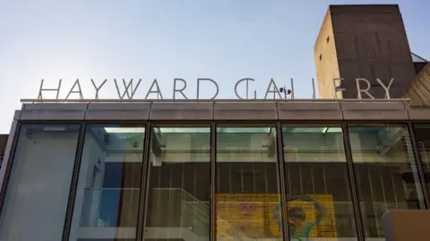 The Southbank Centre A sign reading Hayward Gallery with a brutalist glass building below.