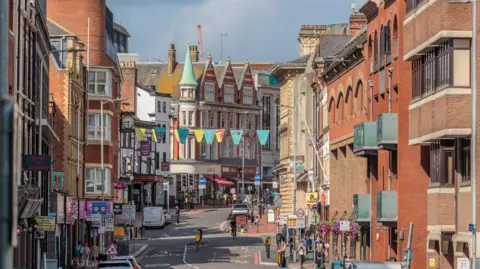 Getty Images A picture of Reading town centre, with shops on the left side and flats and offices on the right side.