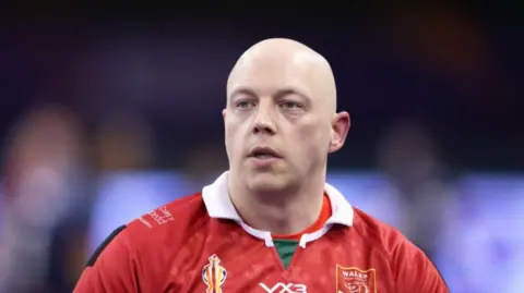 Getty Images Scott John Trigg-Turner, a bald man in a red rugby jersey.