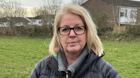 BBC Woman wearing classes in open field 