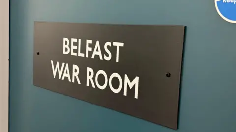 A sign on a blue door says Belfast War Room