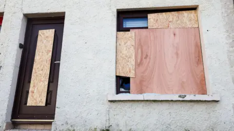 Pacemaker Boarded up window and door of house in Kilburn Street, Belfast