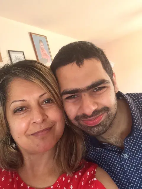 Family handout/NHS Blood and Transplant Bevi Sandhu with shoulder length hair and Sunni Bansal with a dark beard press their heads together and smile at the camera