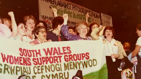 Glamorgan Archives Women from a miners' support group holding a banner