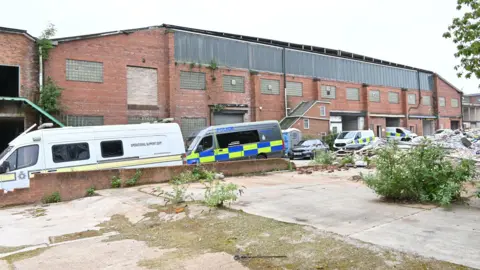 Nottinghamshire Police Police vehicles outside the warehouse in Mansfield. 