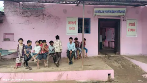 Vikram Singh Chouhan Children sit outside Mor Singh's house, with pink walls, in India's Rajasthan