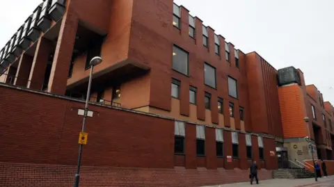 Imposing red brick building spread across four storeys with windows on each floor