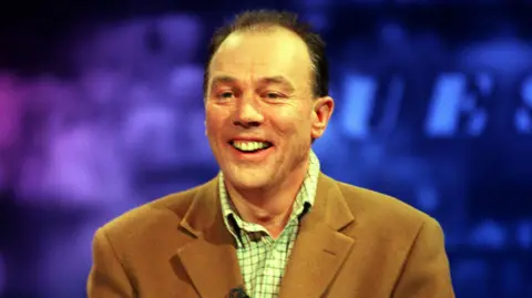 PA Media A screen grab of Stagecoach tycoon Brian Souter during a televised debate on BBC's Question Time. A balding man, he wears a camel blazer and a green checked shirt.