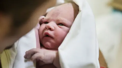 Getty Images A baby is held in a blanket