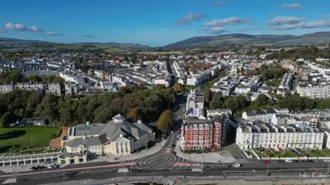 MANX SCENES An aerial view of Douglas, you can see the roundel in the foreground, in the background there is a lot of housing, and a hill behind.