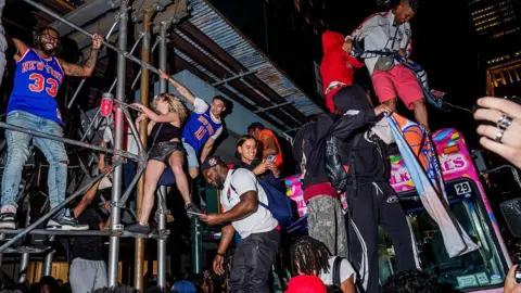 Getty Images People climb building construction and an ice cream truck 