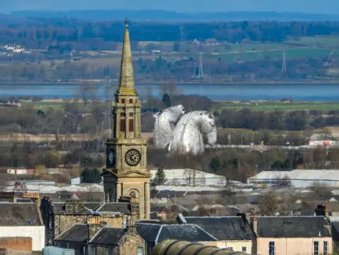 Nathan Young The Kelpies, two very large horse head sculptures, surrounded by buildings and green spaces