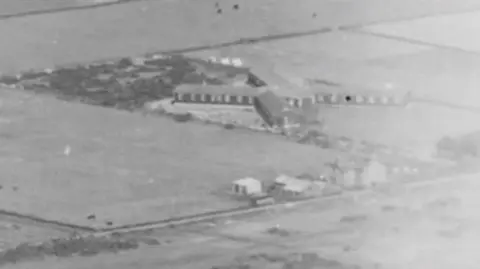 Natural Resources Wales  An aerial photo in black and white showing the former military camp from the air in a wartime photo.