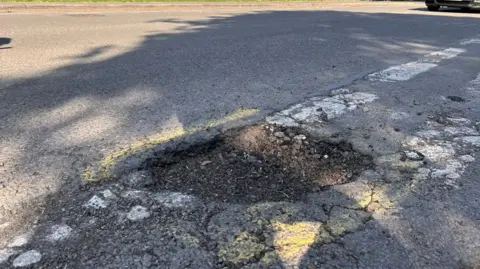 Pothole with a yellow ring painted around it