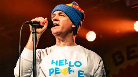 Getty Images EMD singer James Atkin singing into a microphone