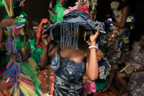 EMMANUEL ADEGBOYE / EPA A women wearing a shredded denim stetson hat and a matching denim dress.
