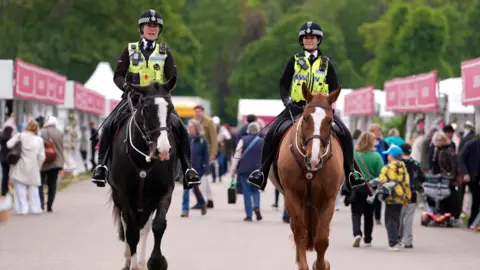 Mounted police make their way past shops during the Royal Windsor Horse Show