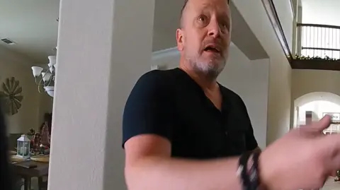 Courts and Tribunals Judiciary Police body-cam footage showing Kris Harrison, who is bald and has grey stubble, looking distressed