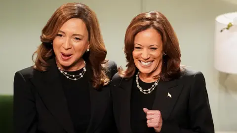 Reuters Democratic presidential nominee and U.S. Vice President Kamala Harris reacts next to Maya Rudolph as she makes an appearance on Saturday Night Live in New York City